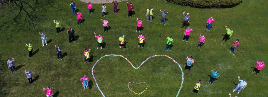 employees on lawn with thank you signs