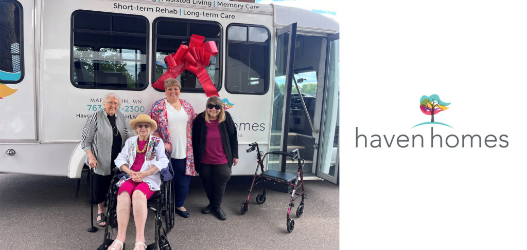 Haven Homes residents and staff stand proudly in front of their new bus, decorated with a large red bow, symbolizing the community's excitement for new adventures.